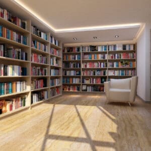 Image of a library with shelves full of books and a small armchair sitting in the corner.