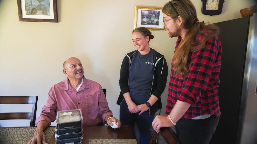 Two volunteers chatting with a senior