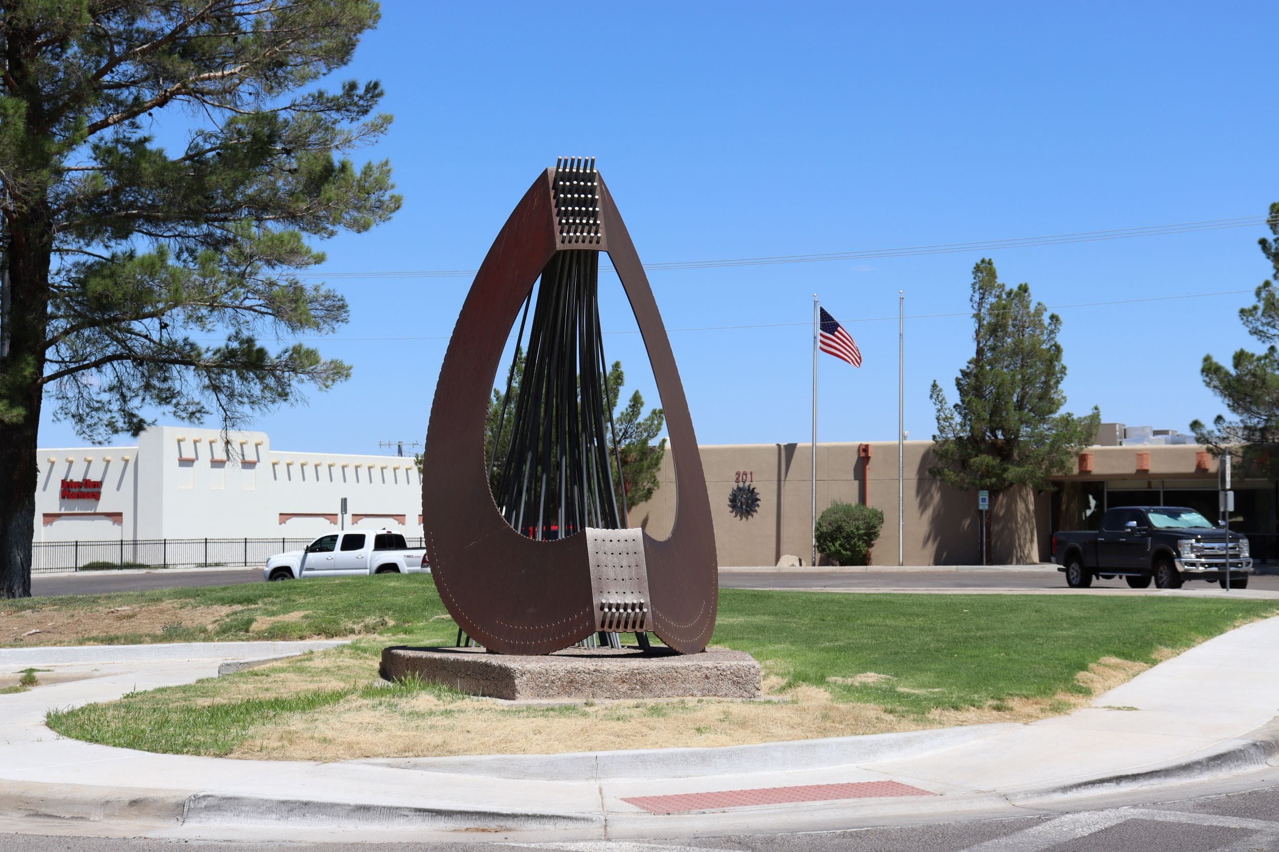 Photo of back view of sculpture with police department in background