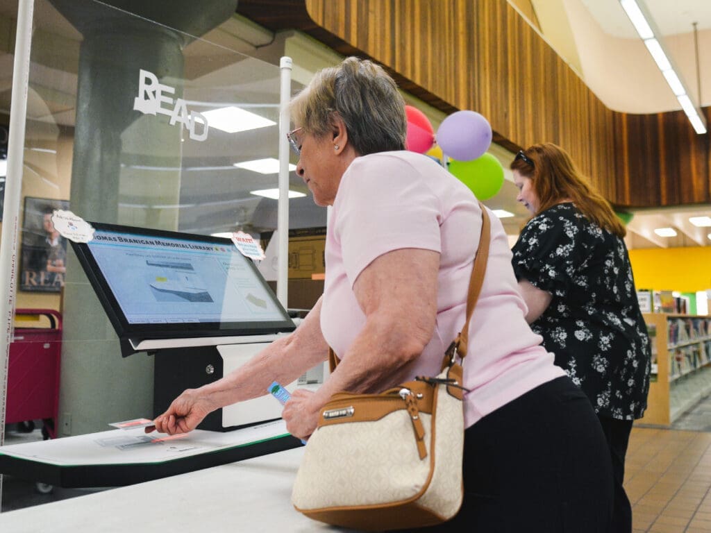 Two women check out books at the library.