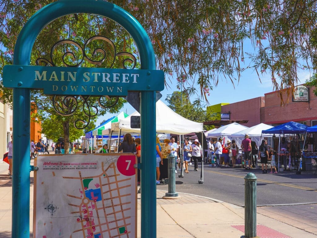 A sign next to a street full of people labeled "Main Street Downtown"