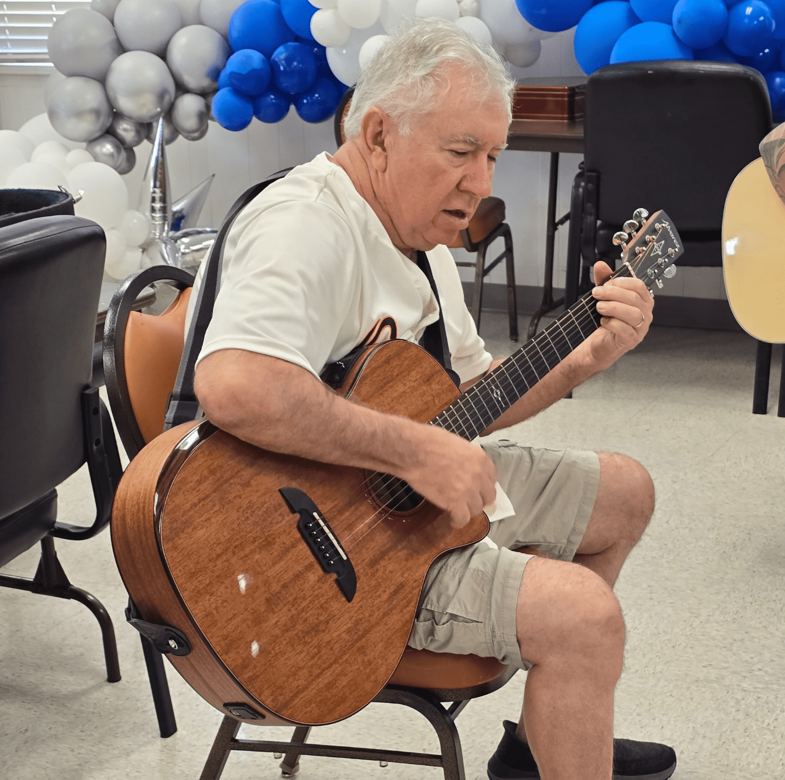 Senior male playing guitar at Eastside