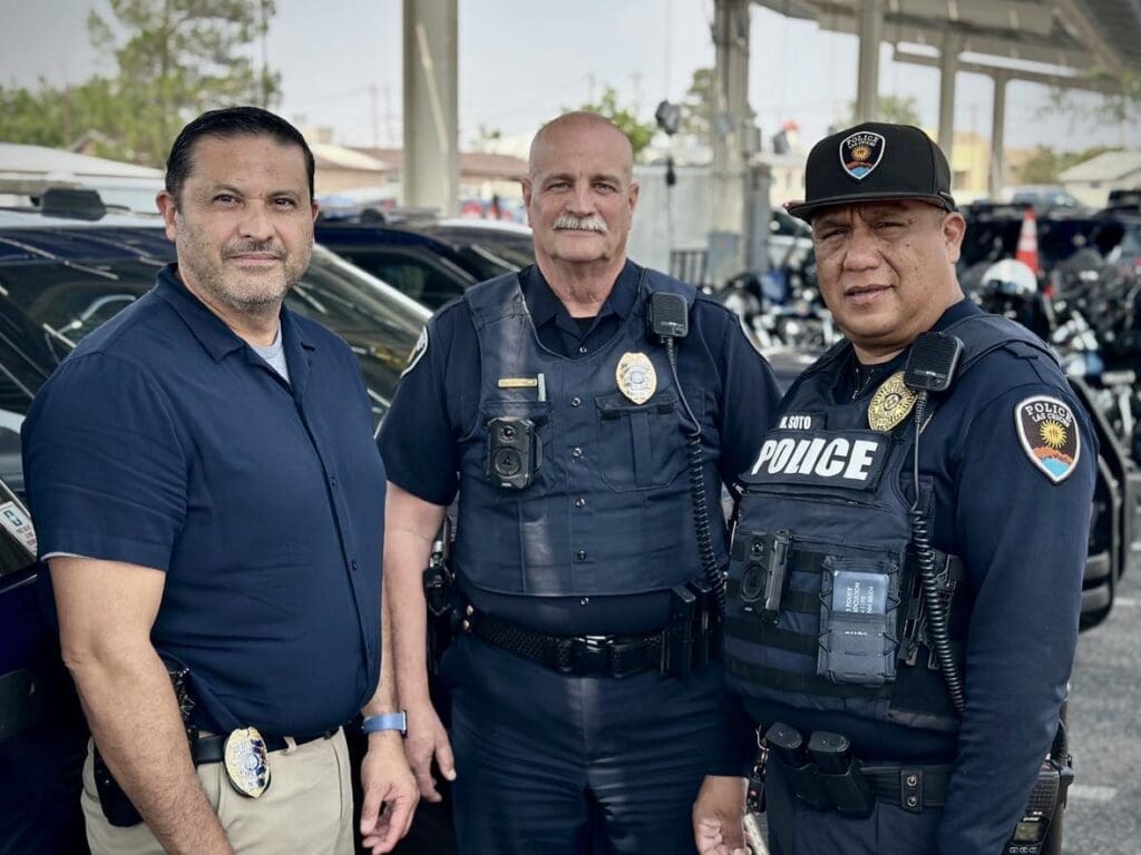 Three Las Cruces Police Department officers, two in uniform, standing together.