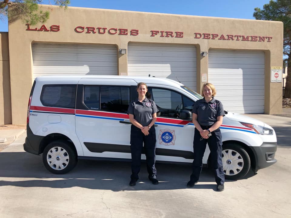 Two interns standing in front of the Las Cruces Fire Department's Mobile Integrated Health van.