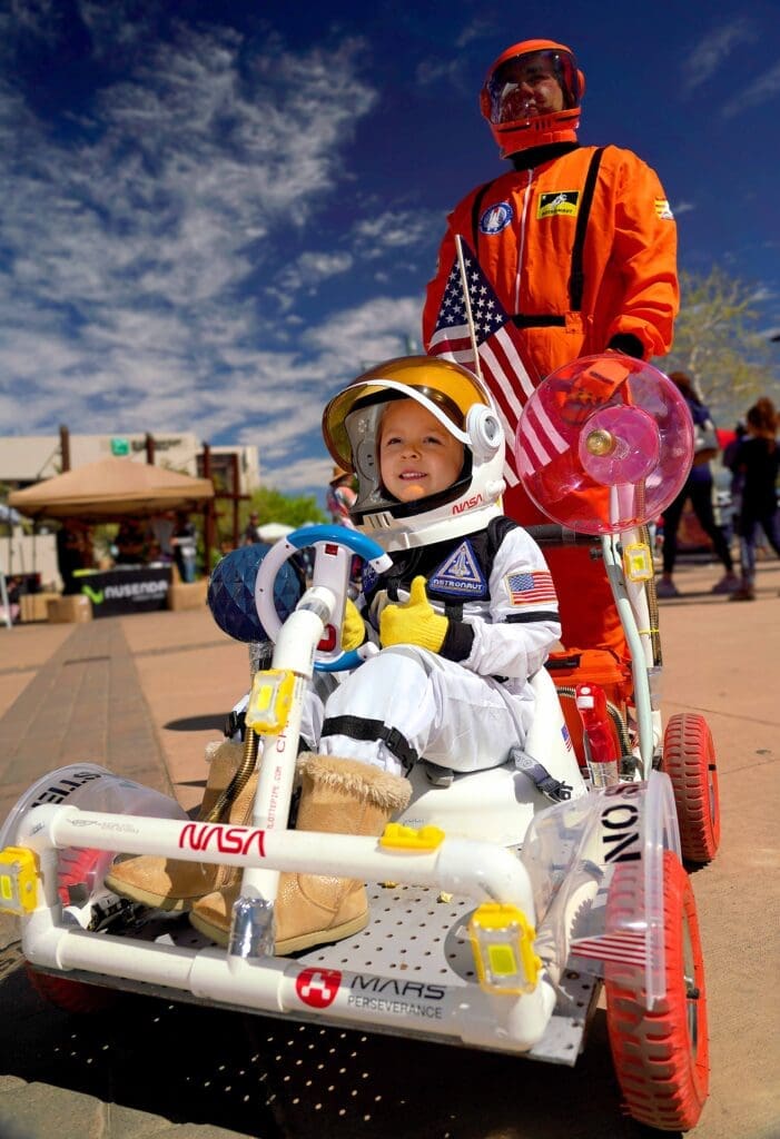 Child in a space suit riding a go-cart