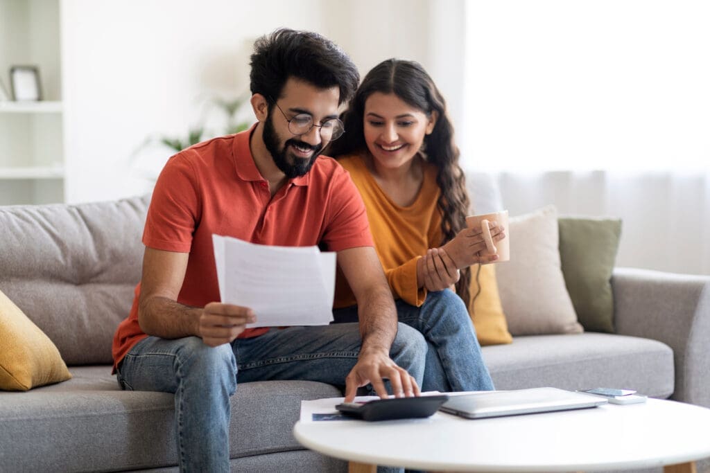 Couple looking at their bill and smiling.