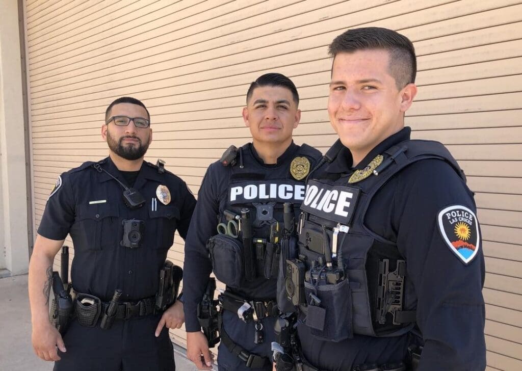 Three police officers stand in uniform