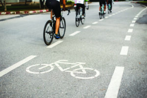 Bike Riders on road with bike path sign on road