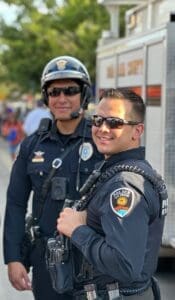 Two officers, standing outside, looking at the camera.