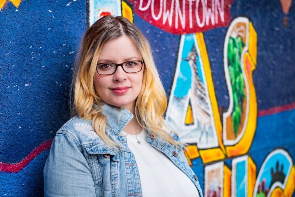 Tina Ballew posing in front of mural