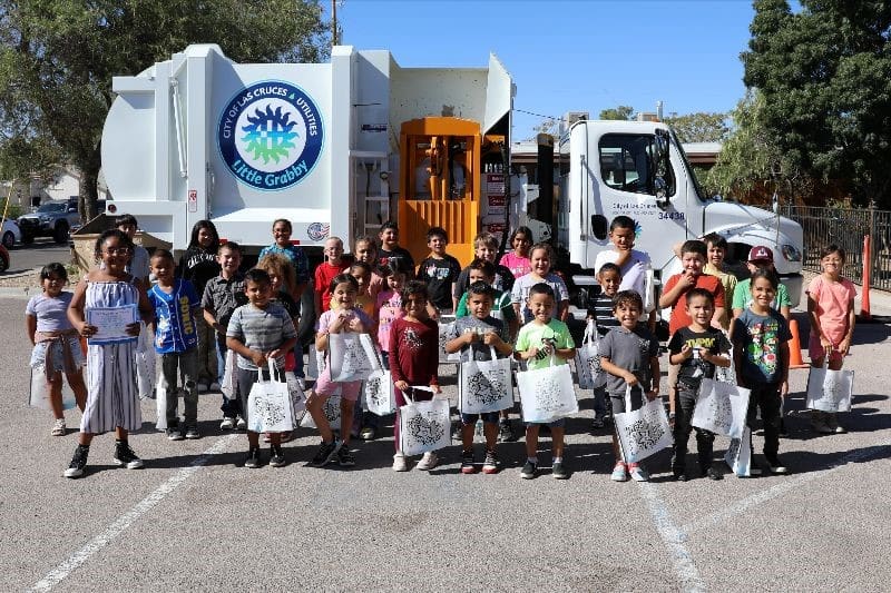 Children standing in front of garbage truck