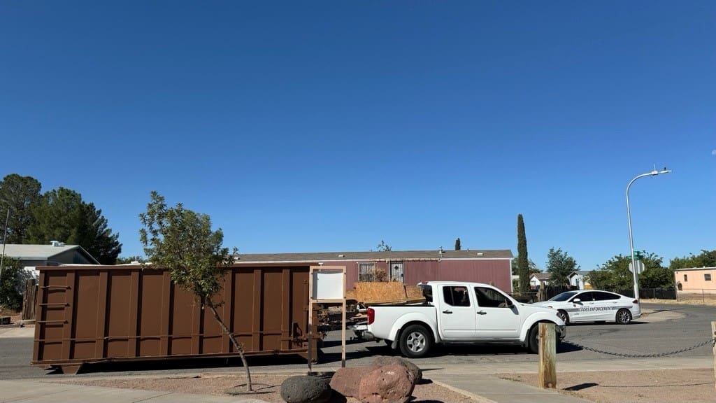 White truck in front of a dumpster