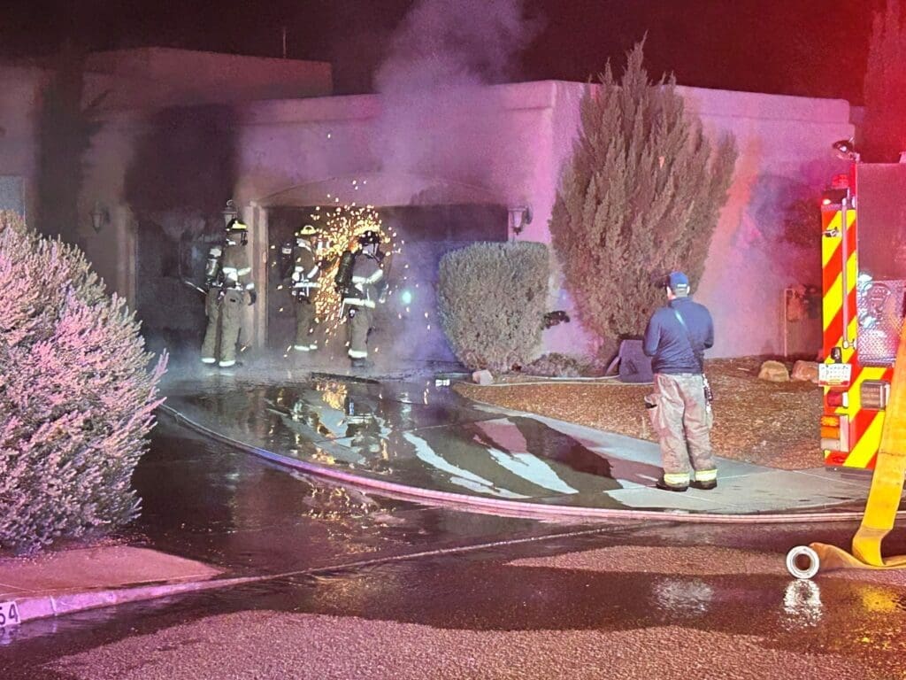 Firefighters spraying water on house fire