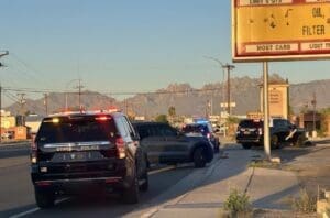 Three police vehicles parked on side of road