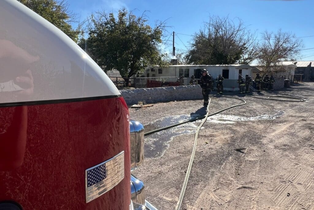 Firefighters standing outside a mobile home