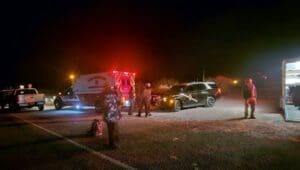Rescue vehicles parked by the side of the road at night.