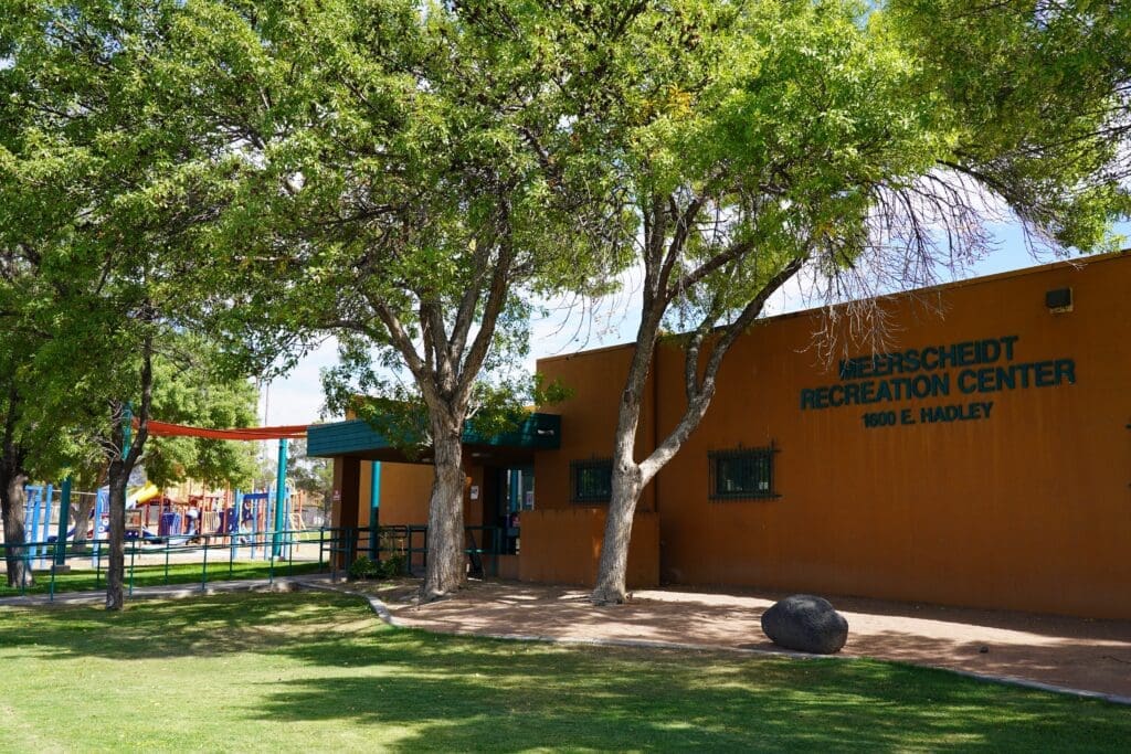 Building with grass and trees in front.