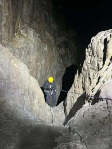 Rescuer in climbing gear climbing down a mountain.
