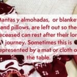 A picture of a red blanket. It reads "Mantas y almohadas, or blankets and pillows, are left out so the deceased can rest after their long journey. Sometimes this is represented by a mat or cloth on the table."