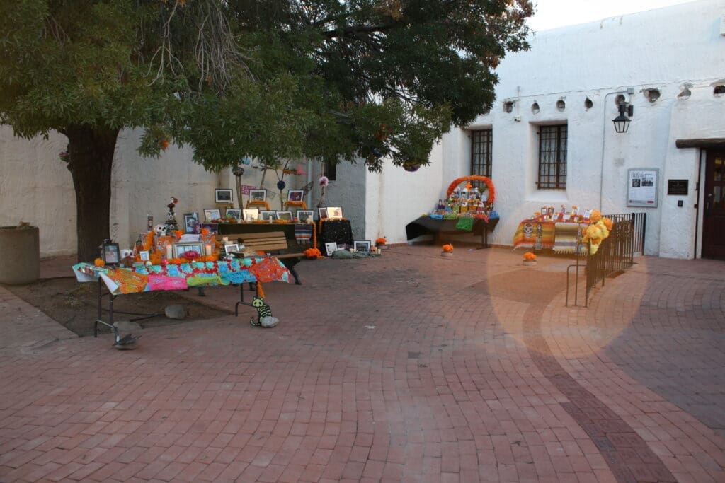 A picture of the museum courtyard with several ofrenda altars set up in it.