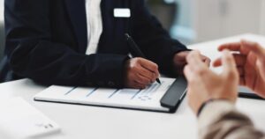 A person filling out an application at a table.