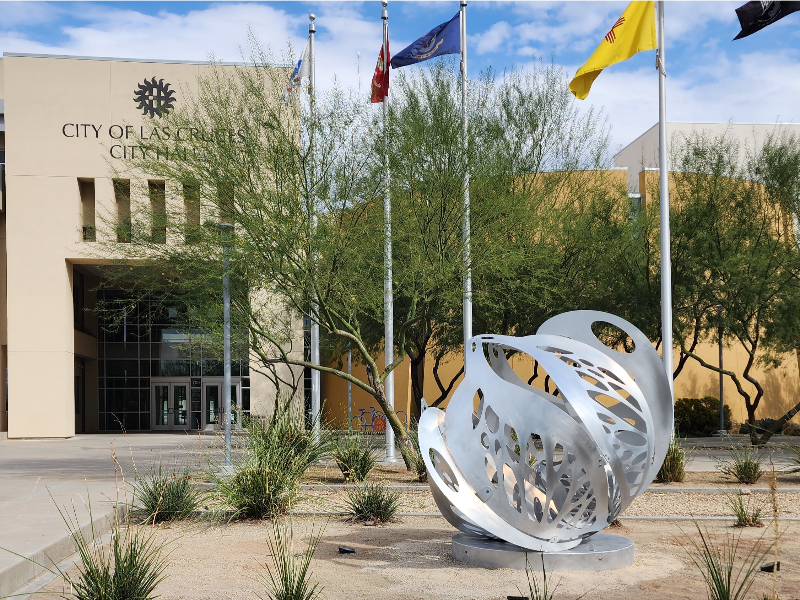 A round sculpture placed in front of the flag poles at City Hall.