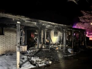 The badly burned porch of a fire-damaged home.