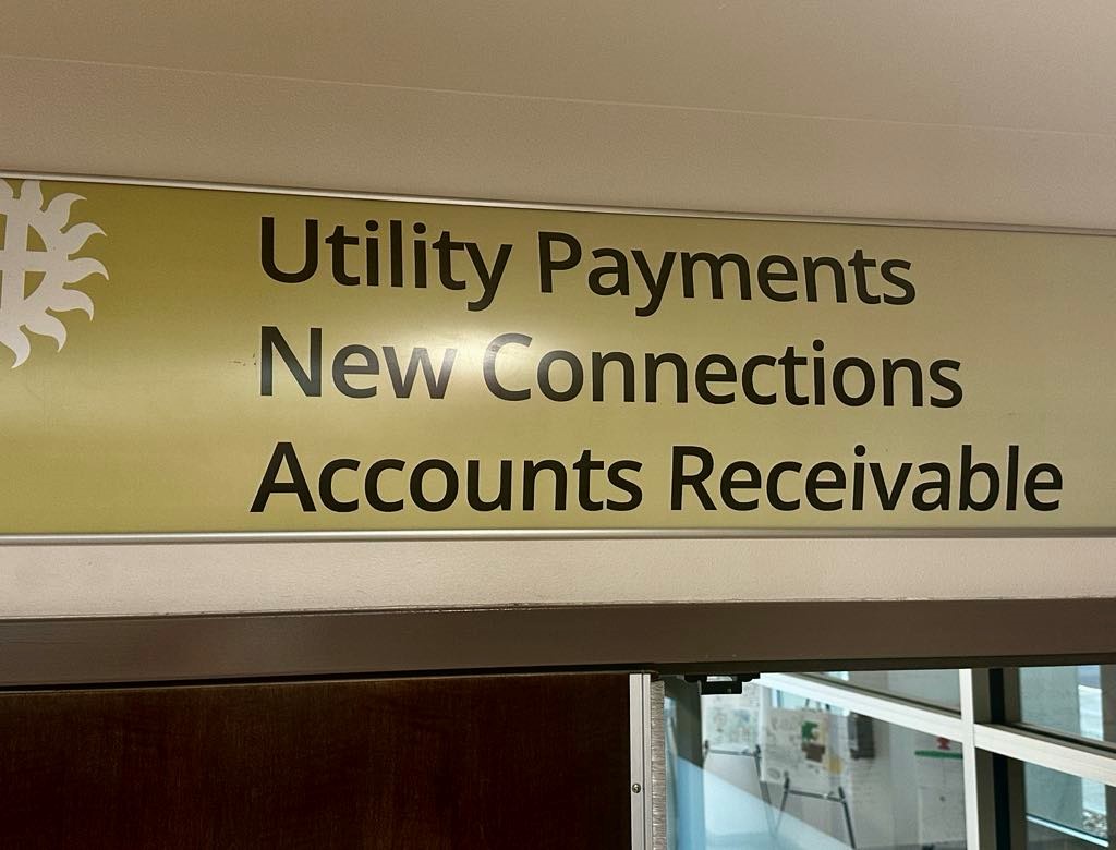 Sign on a wall that says Utility Payments, New Connections, and Accounts Receivable
