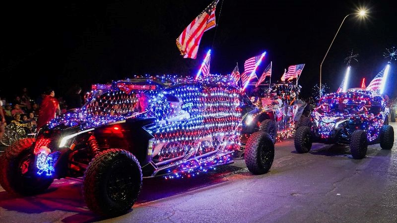 Vehicles with red, white and blue lights wrapped around them in the night.