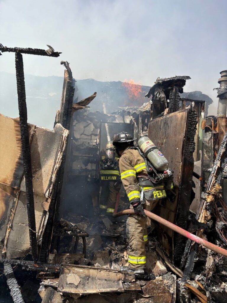 Firefighters fighting a fire in a badly damaged building.