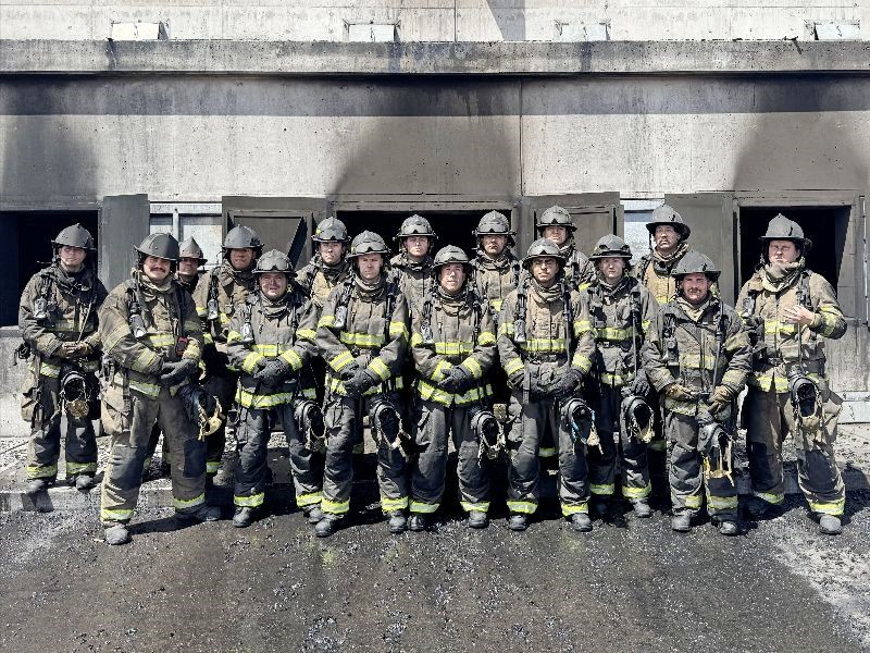 Group of firefighters standing in front of a building.