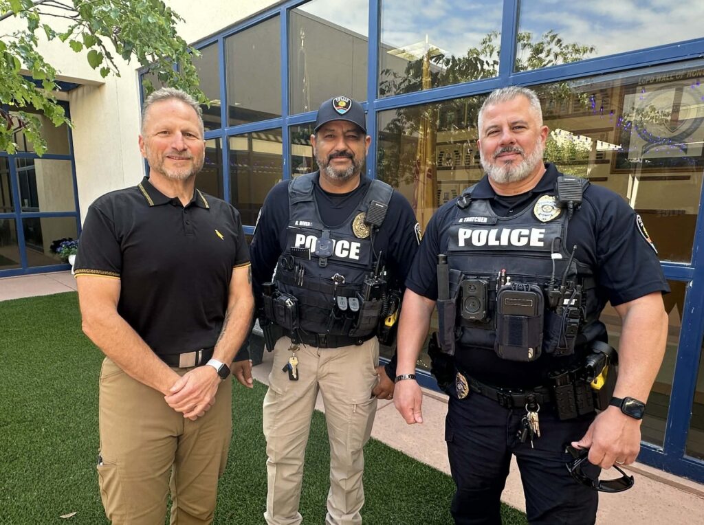 Three older police officers standing in front of a building.