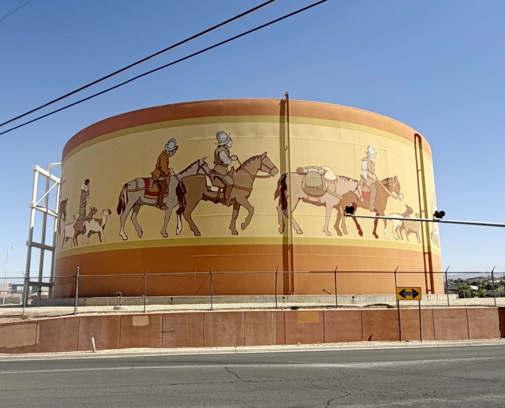 Water tank with men riding horses painted on it.
