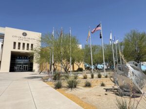 Front entrance to City Hall with flag poles and flags on the right side.