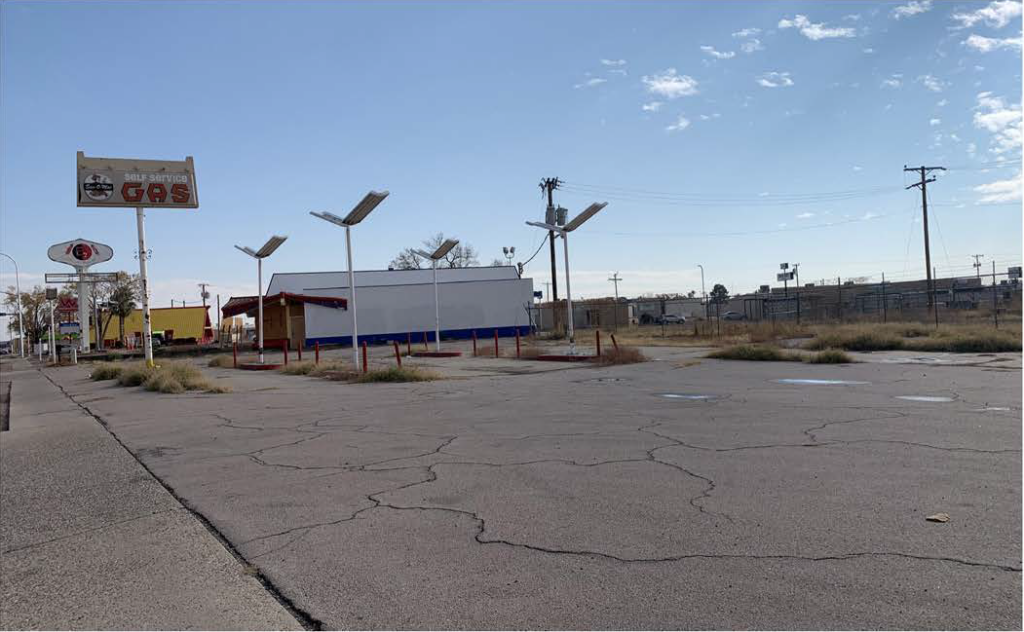 Empty lot with a structure in the background. Possible Brownfield location.