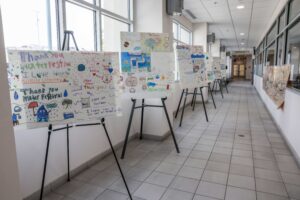 Group of posters on easels in hallway.