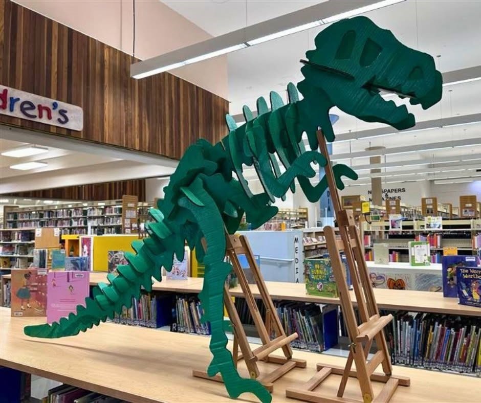 Dinosaur skeleton model on display in a library.