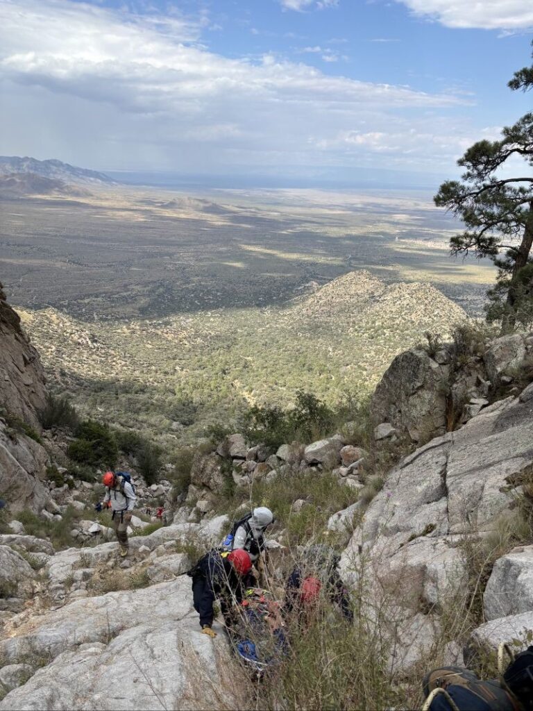 People climbing up a mountain in rocky terrain.