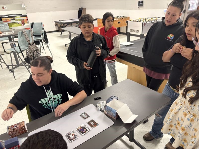 Teens interacting with Parks and Recreation staff at a table.