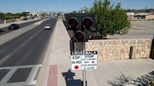 Crosswalk lights with the crosswalk sign beneath it.