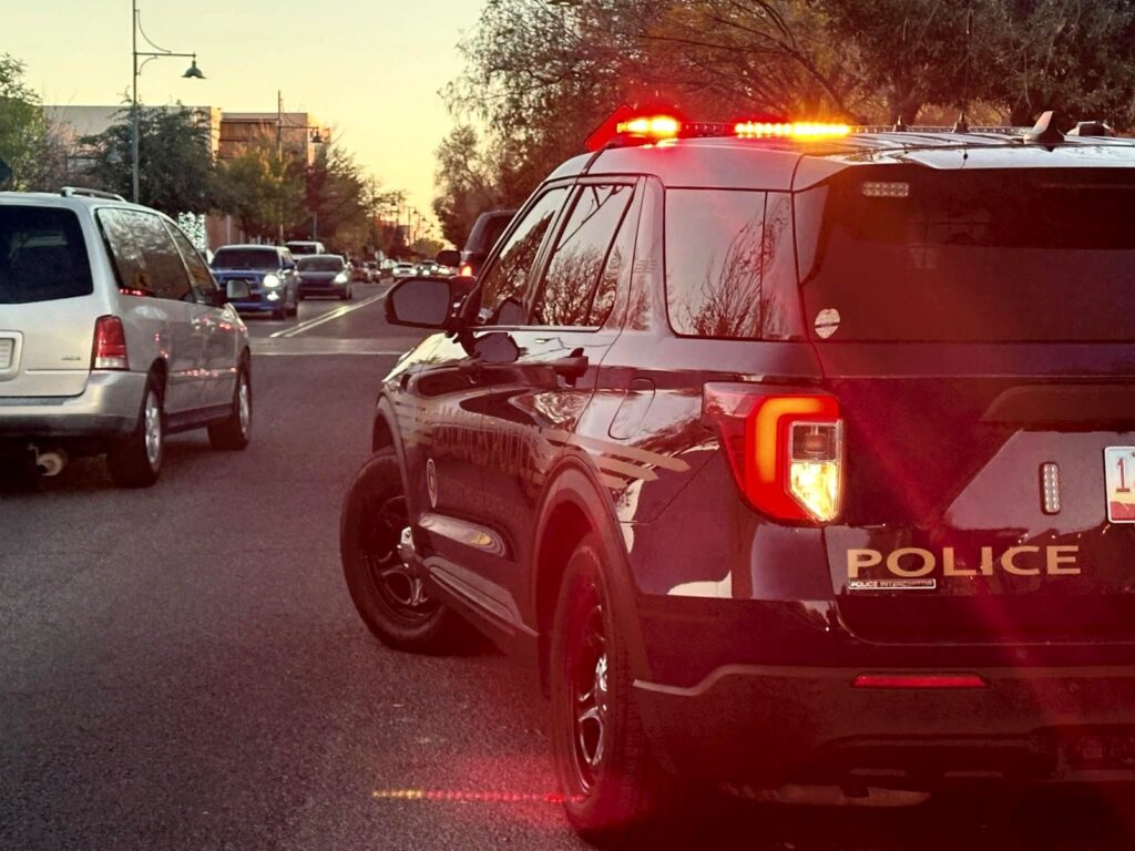 A police vehicle stopped on the side of the road with lights on.
