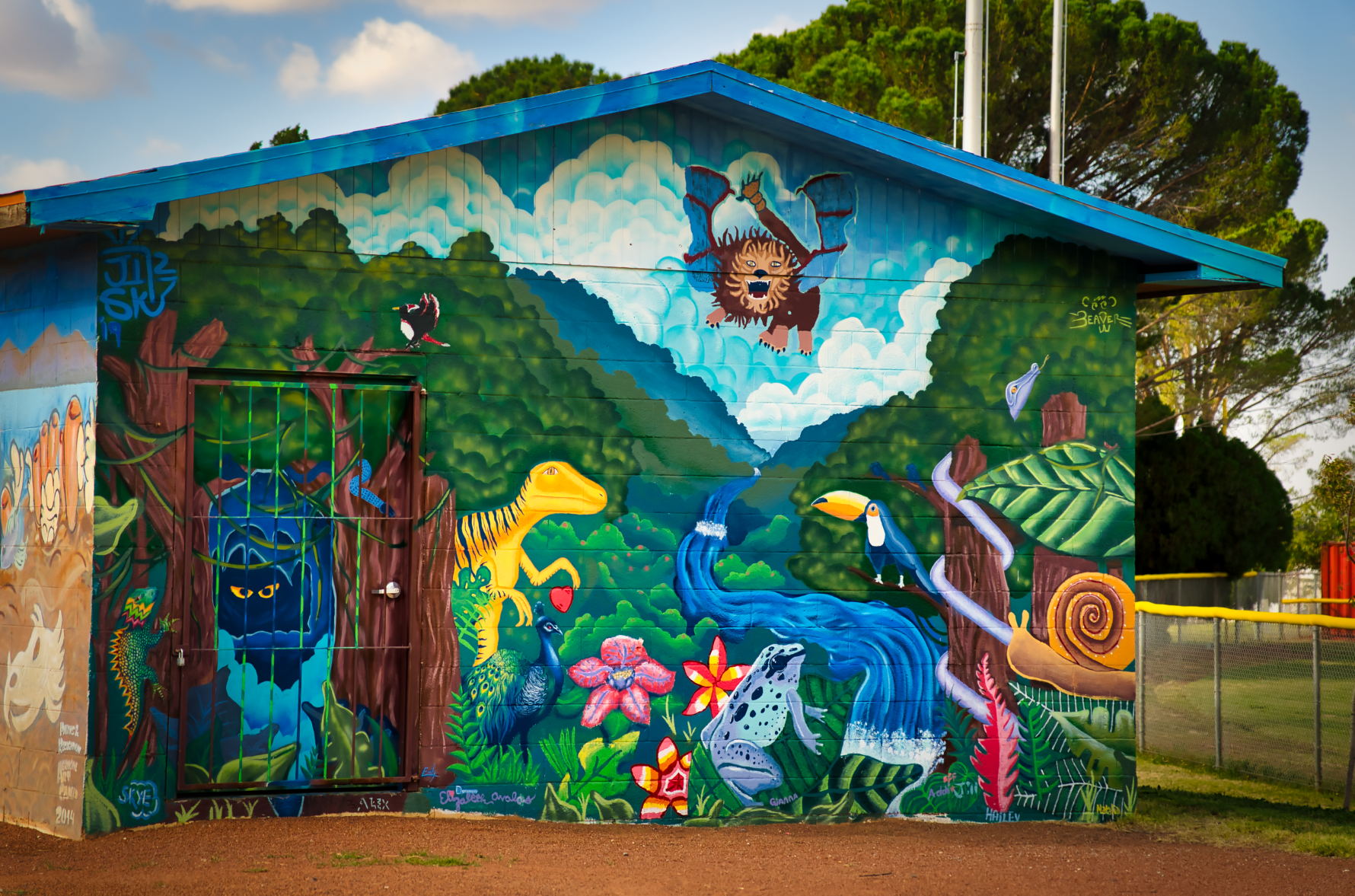 Mural on building with a jungle inspired theme and creatures.