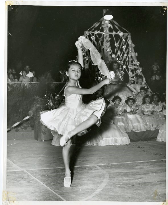 Ballerina dancing in front of a group of girls.