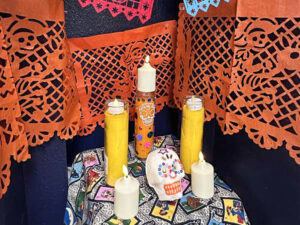 Decor for Dia De los Muertos with candles and a sugarskull.