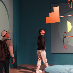Two teens look at art work in a a gallery.